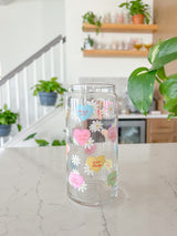 A cute 20oz glass coffee cup that is shaped like a beer can and has different colored candy hearts all over the glass with white daisies. Hearts are yellow, blue, pink, green, and orange and say cute drinks inside the heart.