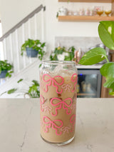 A cute 20oz glass coffee cup that is shaped like a beer can and has pink bows around the entire glass. Large pink bows are hot pink and small pink bows are light pink. Libbey beer can glass cup. 