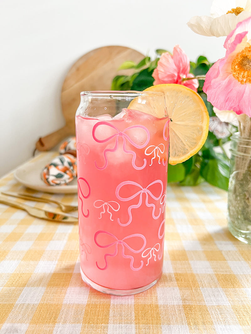 A cute 20oz glass coffee cup that is shaped like a beer can and has pink bows around the entire glass. Large pink bows are hot pink and small pink bows are light pink. Libbey beer can glass cup. 