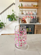 A cute 16oz glass coffee cup that is shaped like a beer can and has purple, pink and hot pink hearts all over the glass with red hearts with doilies around them. The perfect subtle valentine glass or galentine glass. 