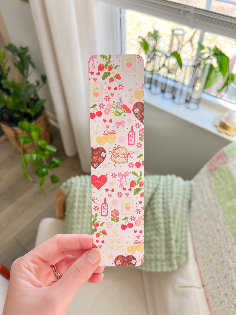 This is a cute bookmark that has different valentine's day designs on it. There are cherries, flower bouquet, heart shaped box of chocolate, bows, flowers, locket, strawberries, and champagne tower. It's a rectangle bookmark made from thick matte paper and high quality perfect for keeping spots in your book. 