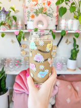 A cute 20oz glass coffee cup that is shaped like a beer can and has different colored candy hearts all over the glass with white daisies. Hearts are yellow, blue, pink, green, and orange and say cute drinks inside the heart.