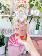 A cute libbey 20oz can glass coffee cup that is shaped like a beer can and has different shade of pink hearts around the glass. 